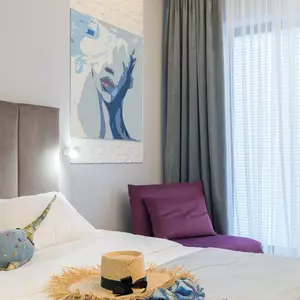 Strohhut und Sommerkleid auf einem Hotelbett